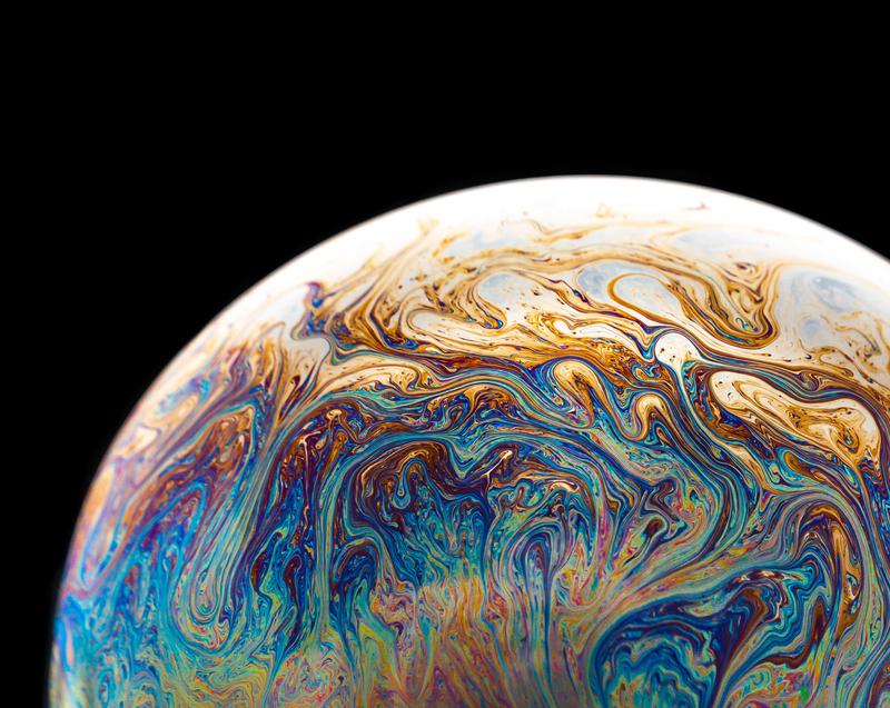 A planet with multi-coloured swirls on a black background